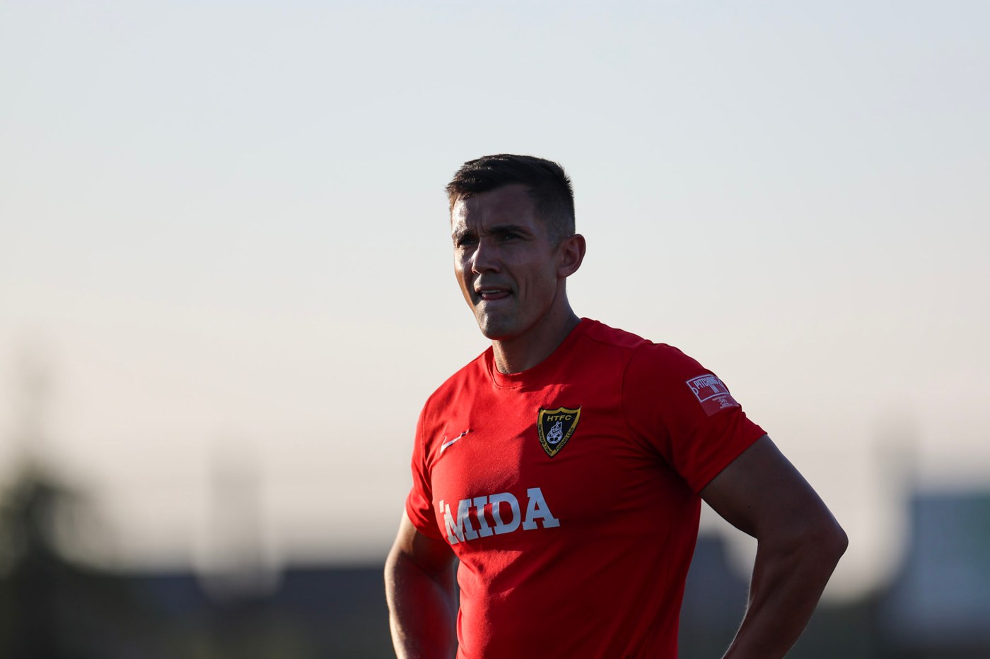 Harborough Town player wearing the red MIDA away shirt